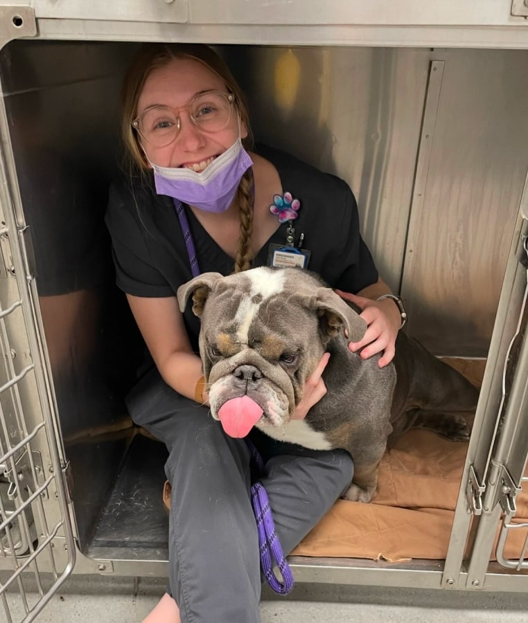 Emergency & Urgent Pet Care Happy lady holding a dog while sitting with the dog